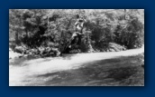 Grandpa Fred Payne McCasland in sling chair crossing river near Northern California Cabin